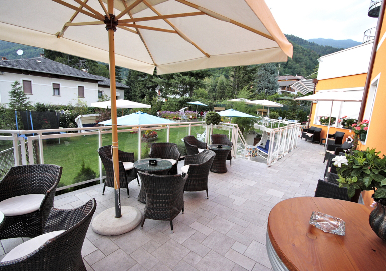 terrazza con poltrone e tavolini del naturebio hotel elite di levico terme